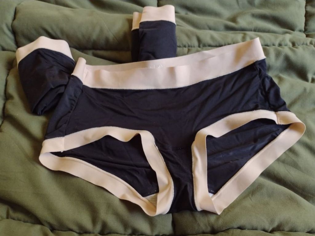 2 pairs of women's hipster panties in black with a nude color band around the waist and leg holes