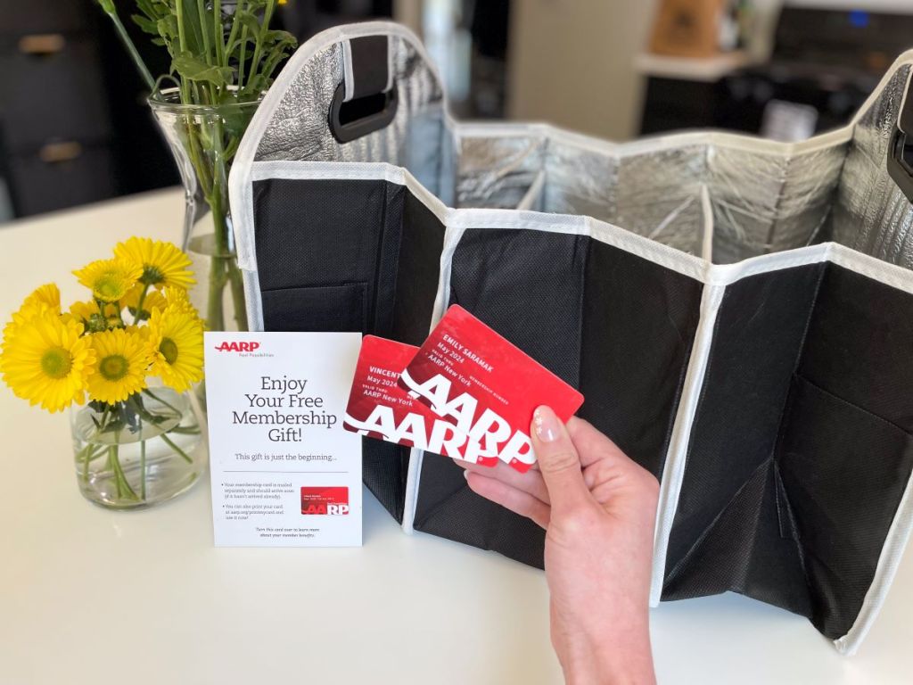 Hand holding AARP cards next to a trunk organizer