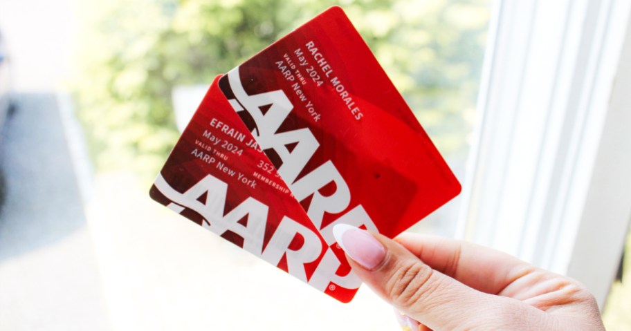 hand holding up two red AARP cards