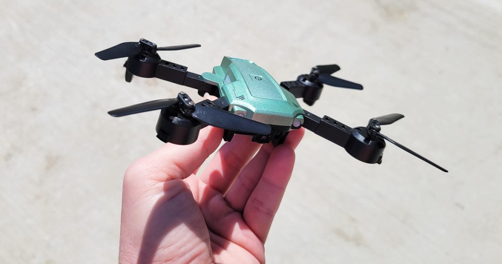 hand holding a mini green and black drone