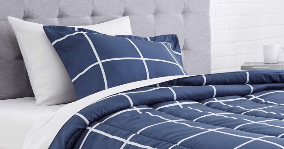 A bed with an Amazon Basics 5-Piece Comforter Set in Navy
