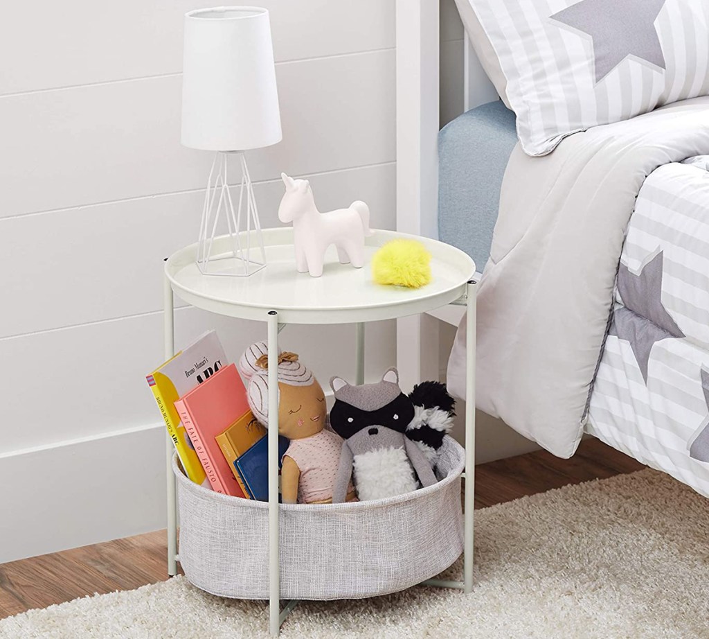 round white side table with grey basket at bottom filled with toys