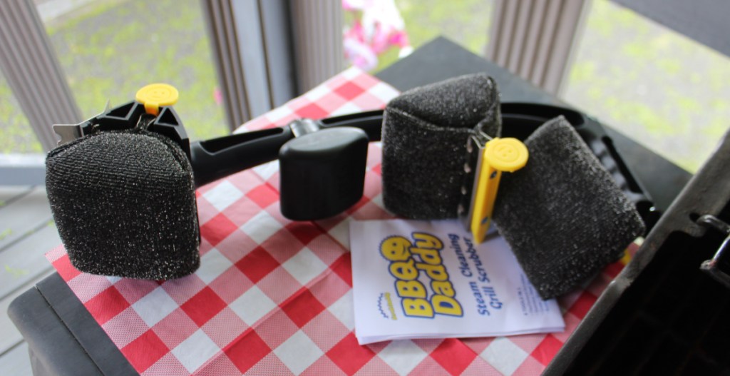 A BBQ Daddy grill scrubber sitting on a grill