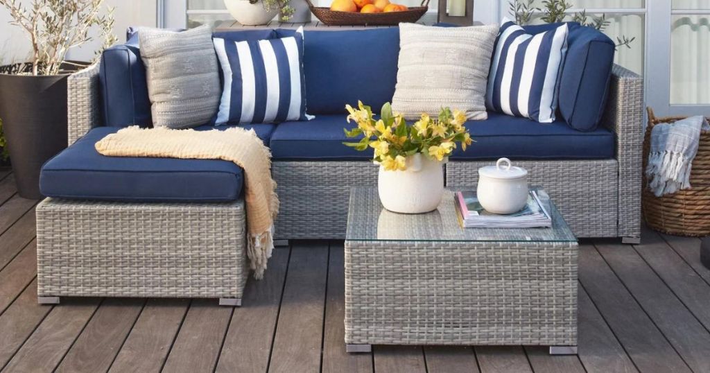 silver wicker outdoor couch and table with glass top on deck
