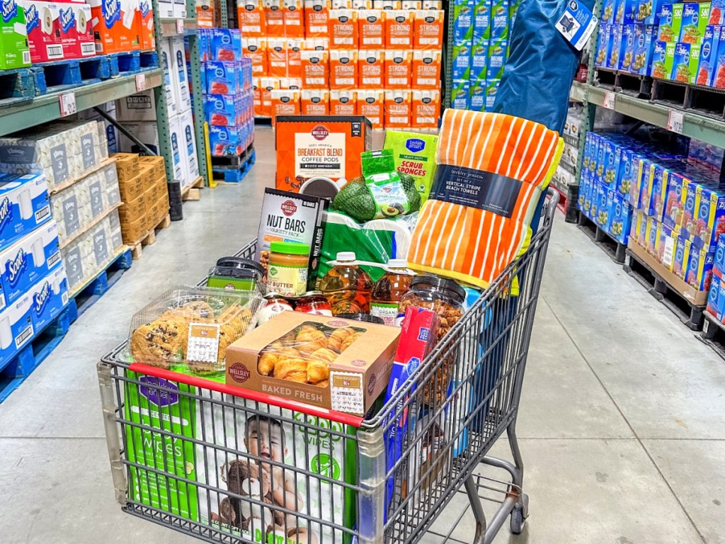 BJ's wholesale club shopping cart full of items parked in an aisle