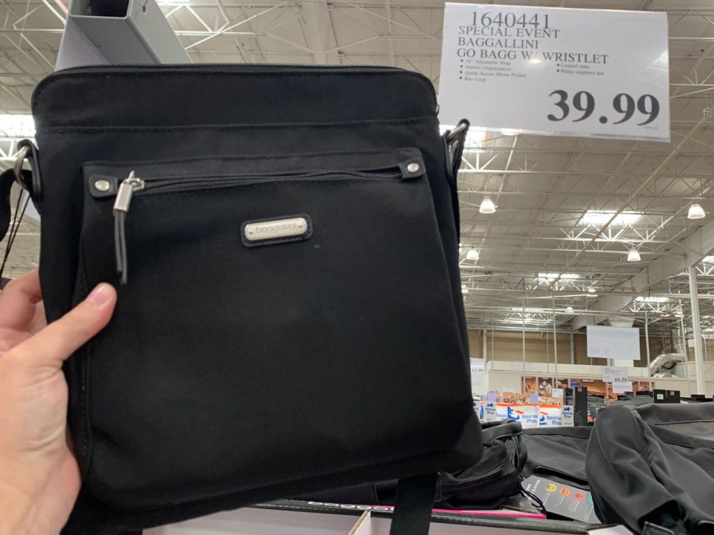 hand holding up a Baggallini Go Bag in front of the price sign at Costco