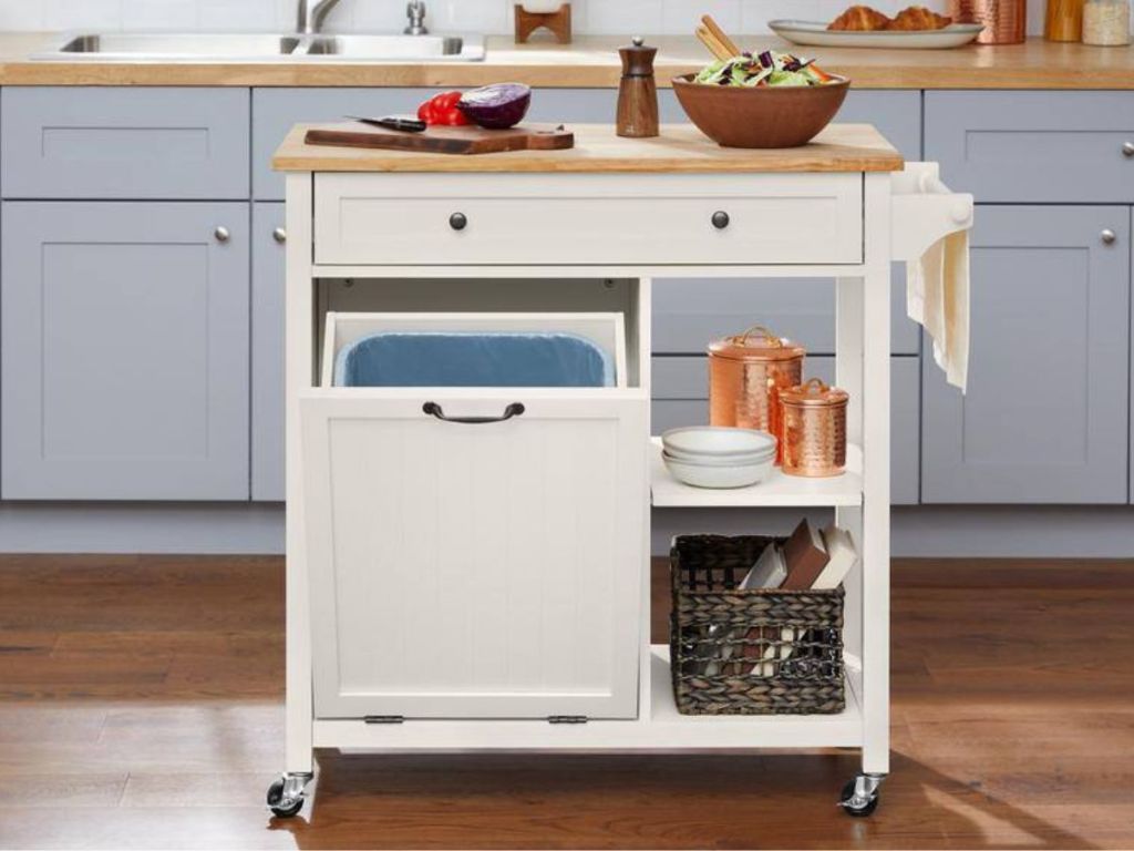 A small rolling kitchen island with trash 