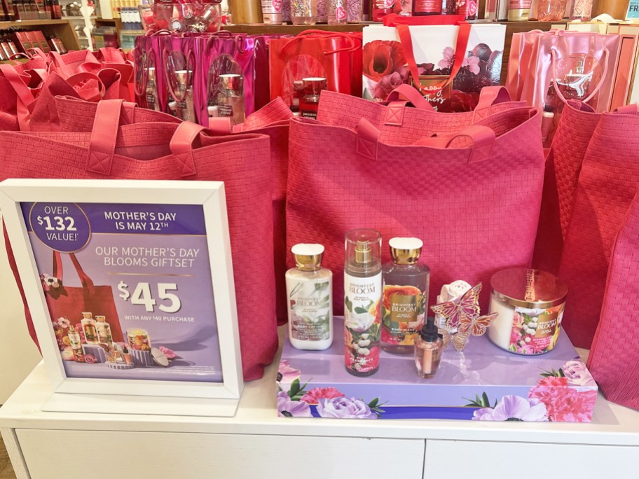 bath & body works products on display in front of pink tote bags