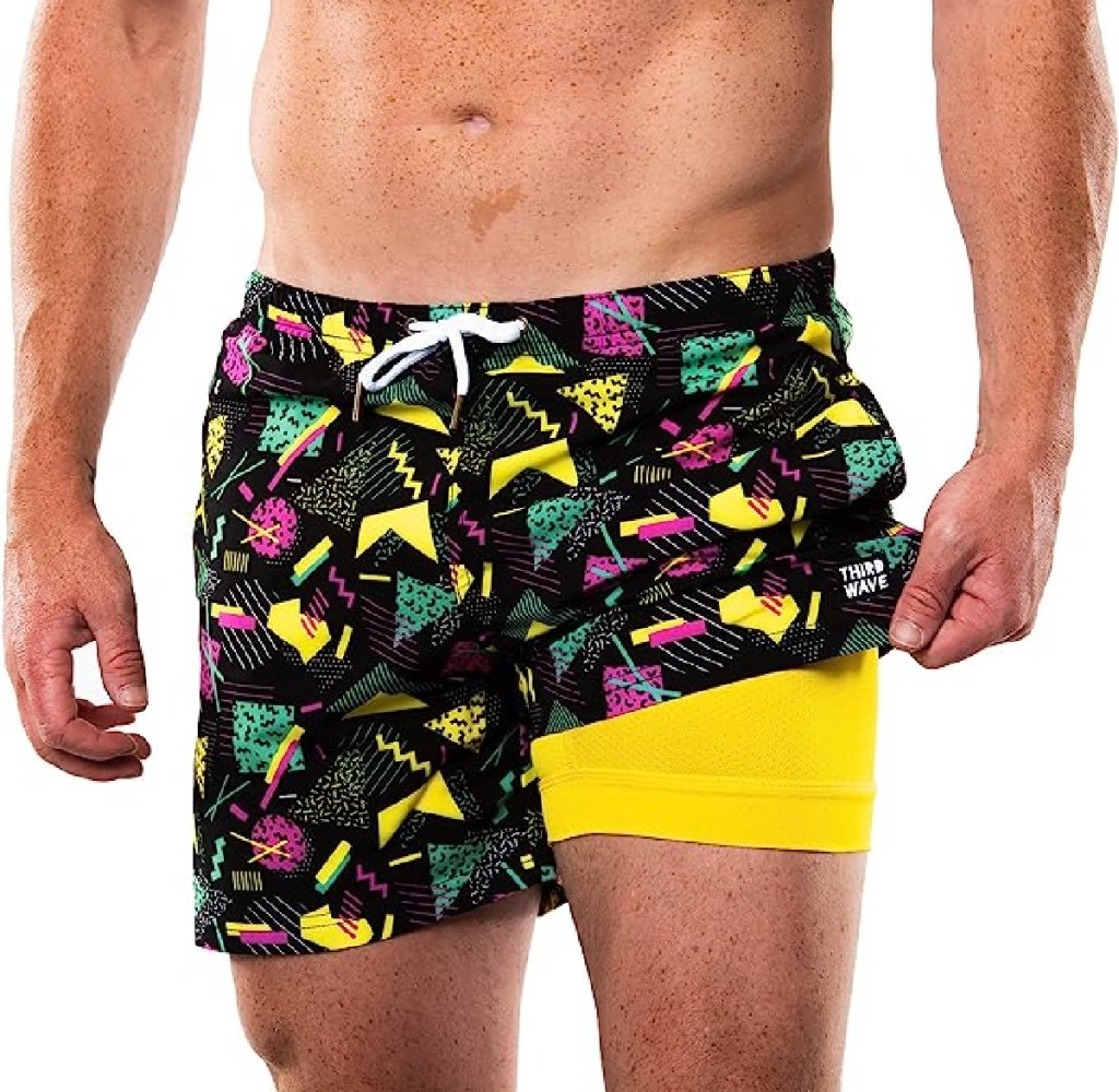man wearing a pair of retro swim trunks with the saved by the bell 90s design 