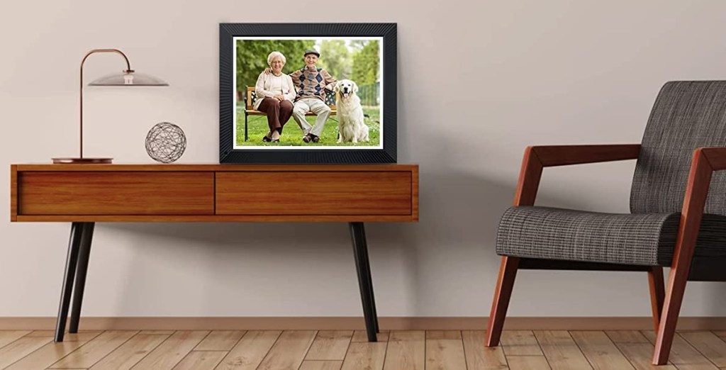 Digital picture frame sitting on a table with a chair next to it
