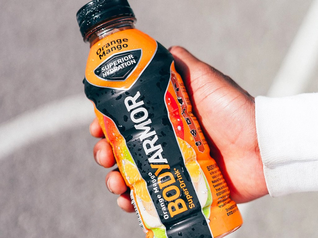 hand holding bottle of orange mango body armour drink