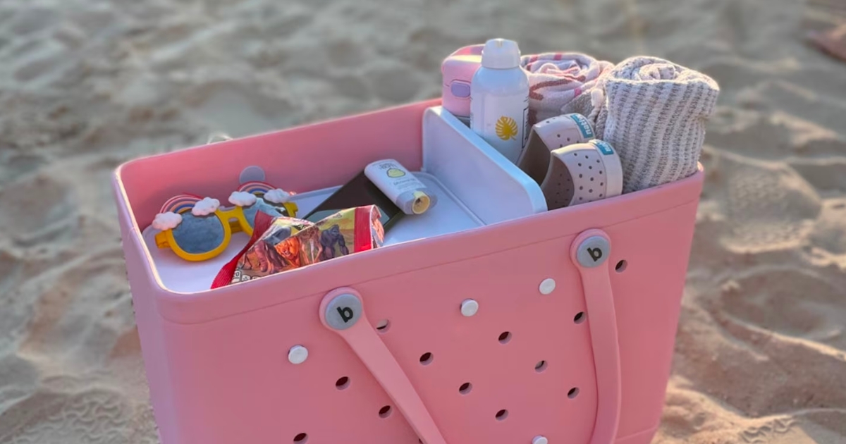 pink tote on sand with divider trays keeping beach stuff organized