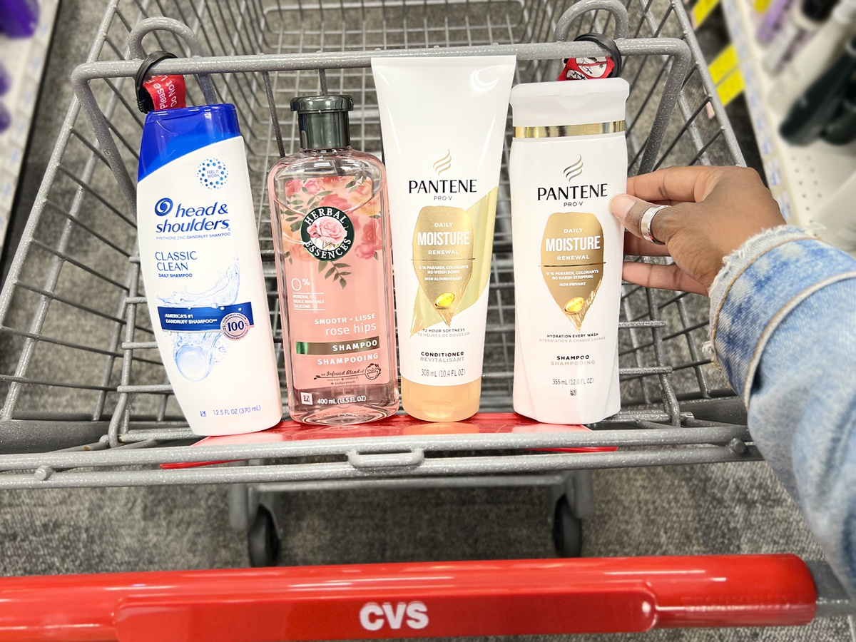 hand placing shampoo and conditioner bottles in cvs shopping cart