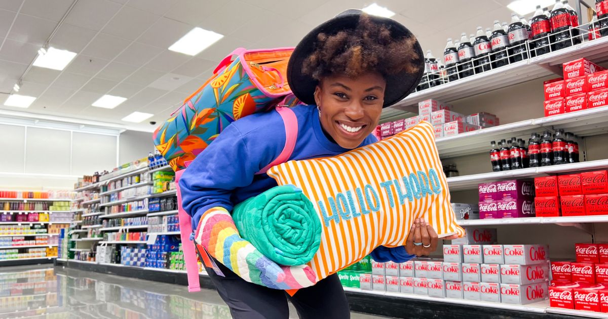 a woman with an armload of Tabitha brown items in a target store 