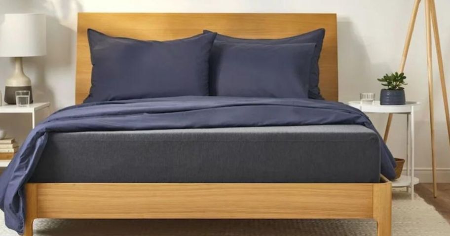 wood bedframe with navy bedding 