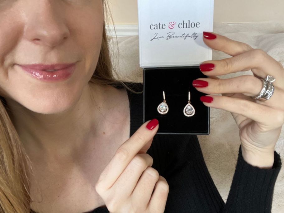 woman holding Cate & Chloe jewelry box showing drop earrings