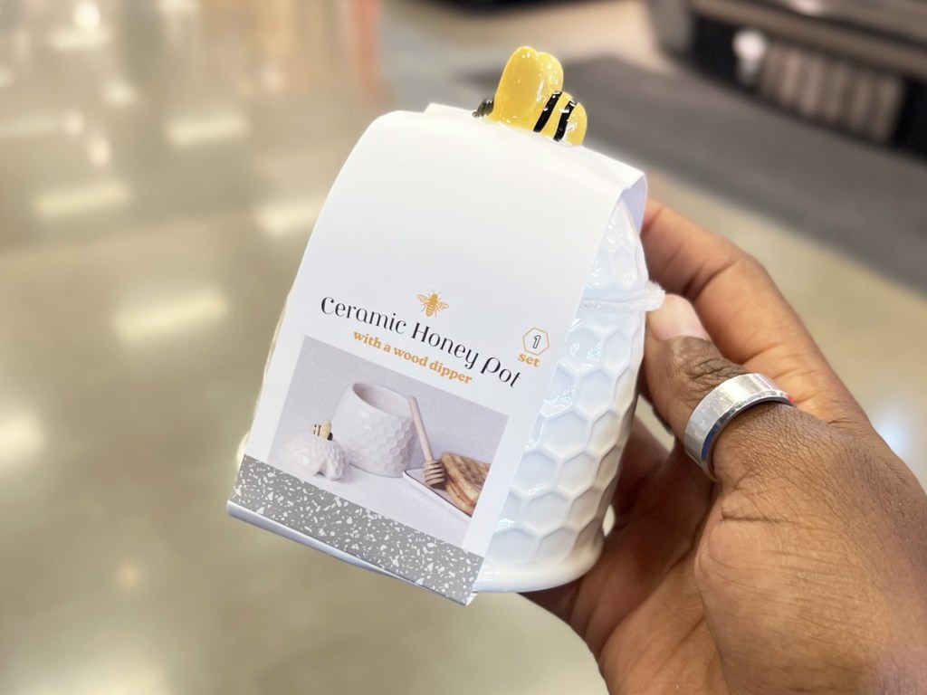 hand holding a white Ceramic Honey Pot with a bee on top