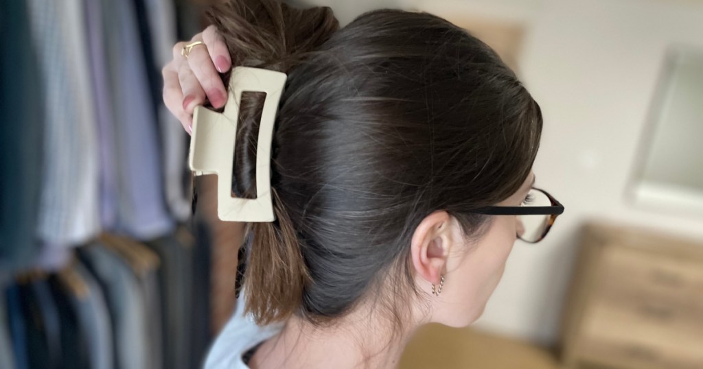 woman holding back of head with claw clip in hair