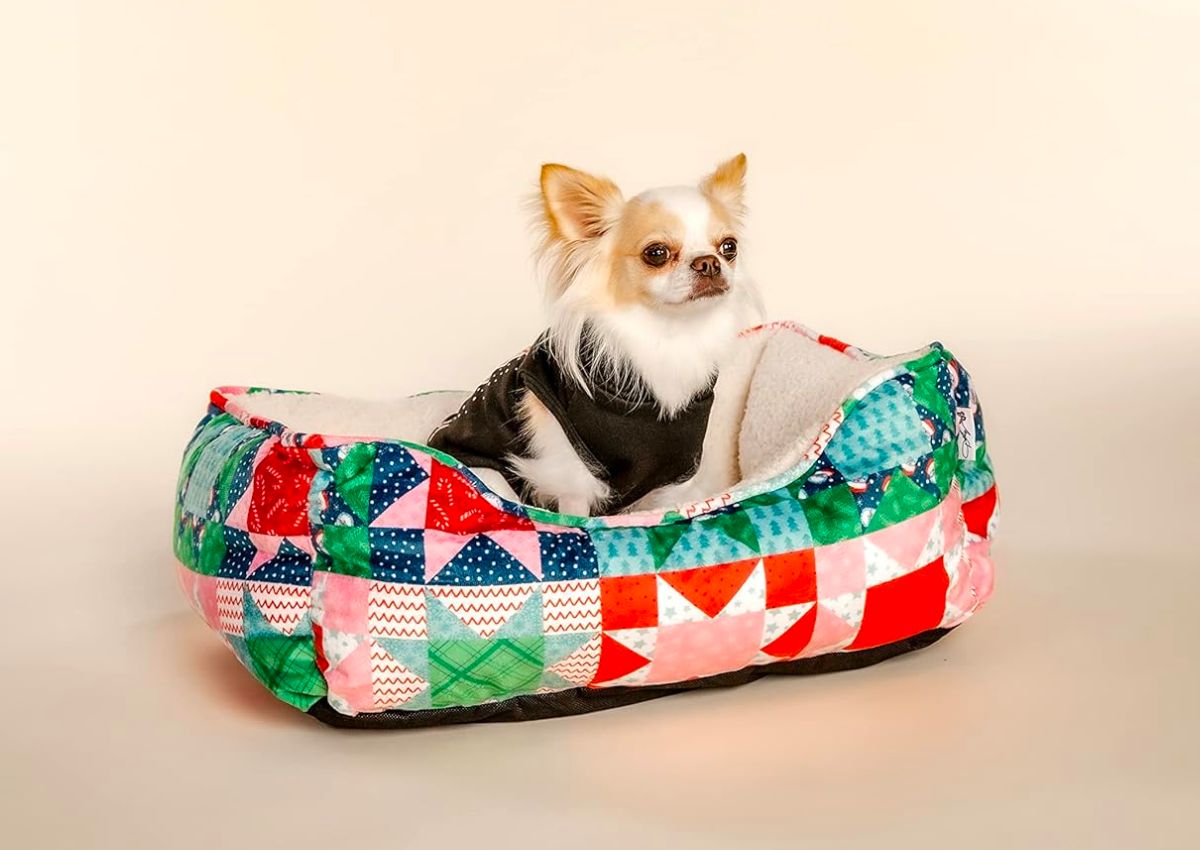 a maltese dog sitting in a Doggy Parton Patchwork Quilt Print Bed for Pets,