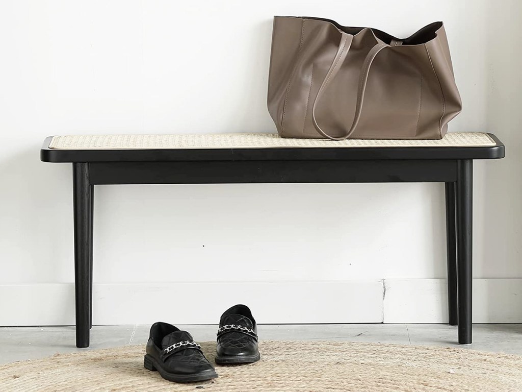 purse on a black bench with a rattan top