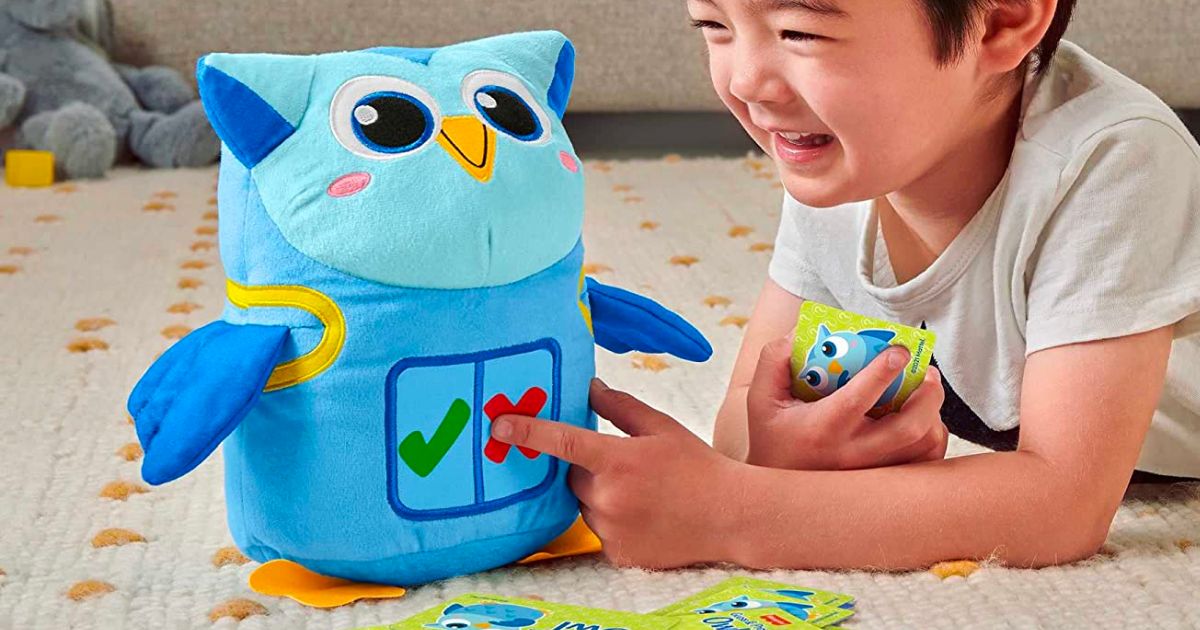 Little boy playing with Fisher Price owl plush
