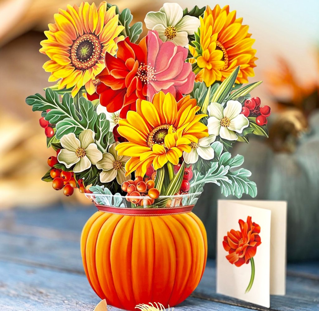 paper bouquet of flowers in a pumpkin with greeting card next to it