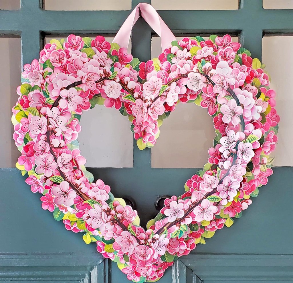 heart wreath made of paper cherry blossoms hanging on door