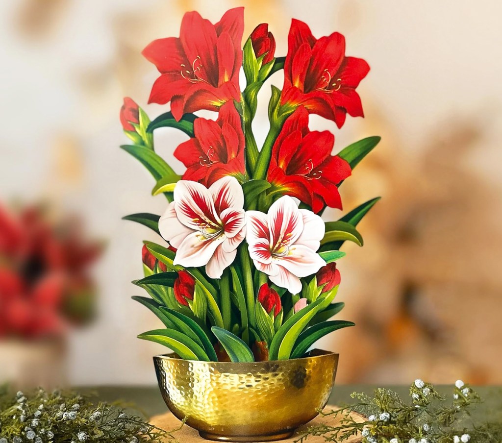 paper bouquet of red and white amaryllis flowers in gold bowl