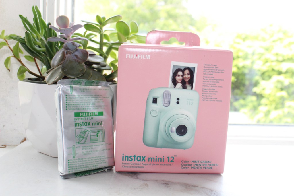 A fuji instax mini 12 camera with film displayed in packaging