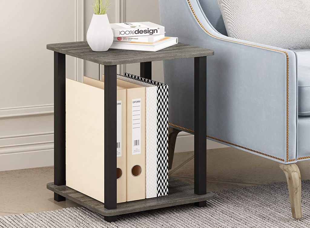 2-tier end table with books on it next to light blue accent chair