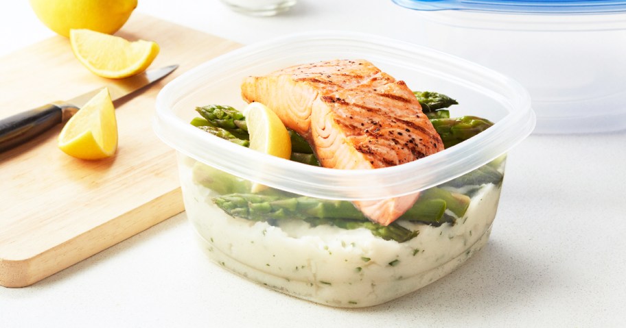 food storage container with mashed potatoes, asparagus, and salmon