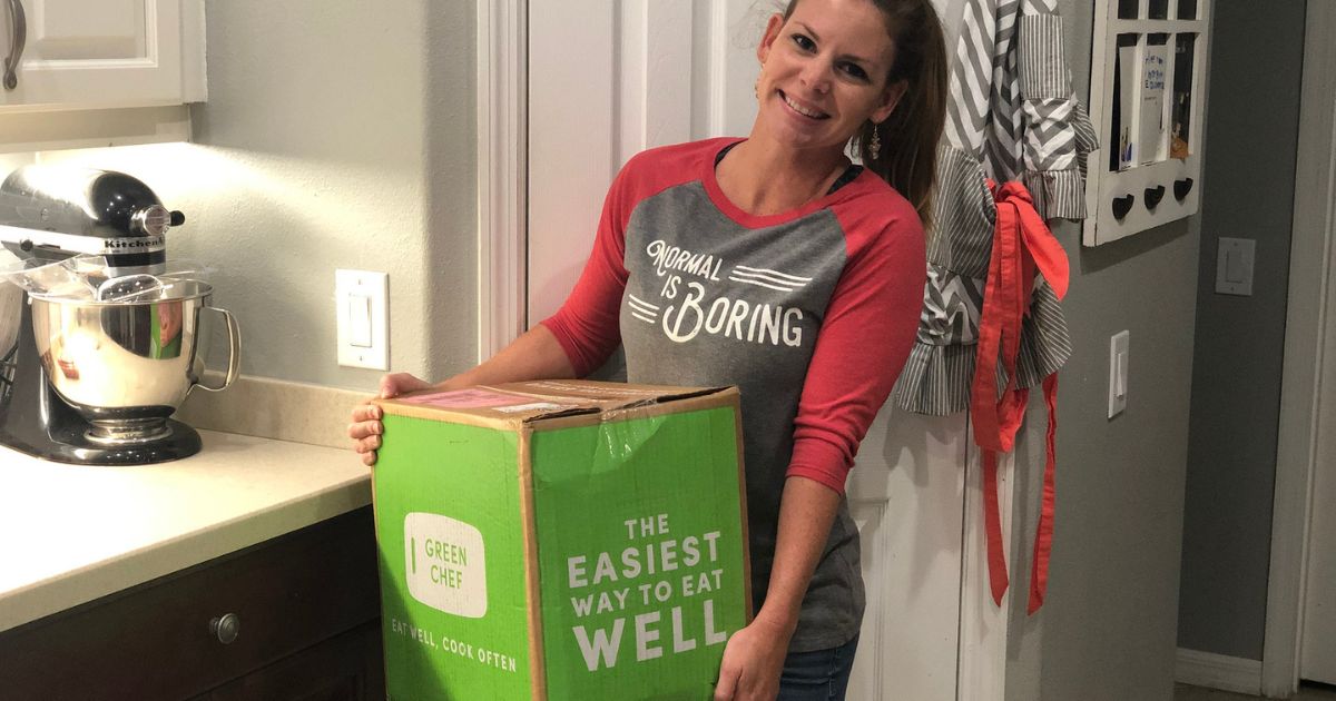 Woman holding a green chef meal delivery box