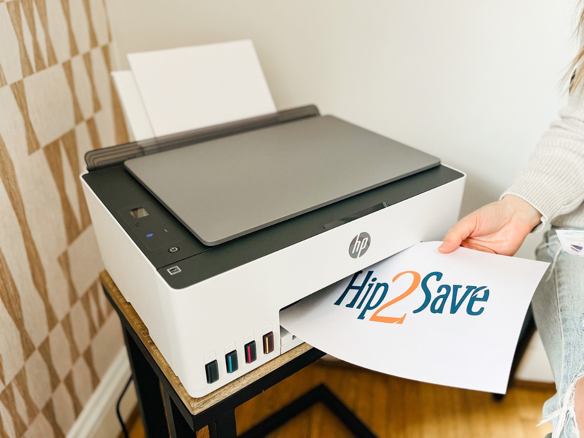 HP Smart Tank 5101 All-in-One Printer with accessories sitting out desk printing out Hip2Save Logo