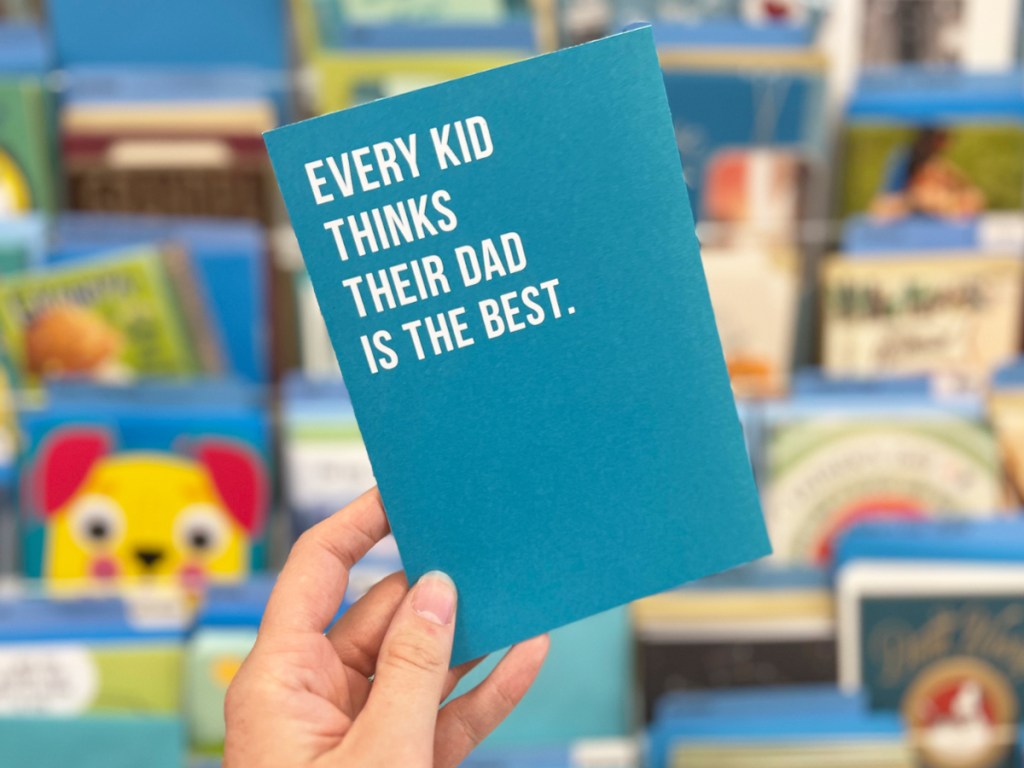 hand holding up a blue father's day card