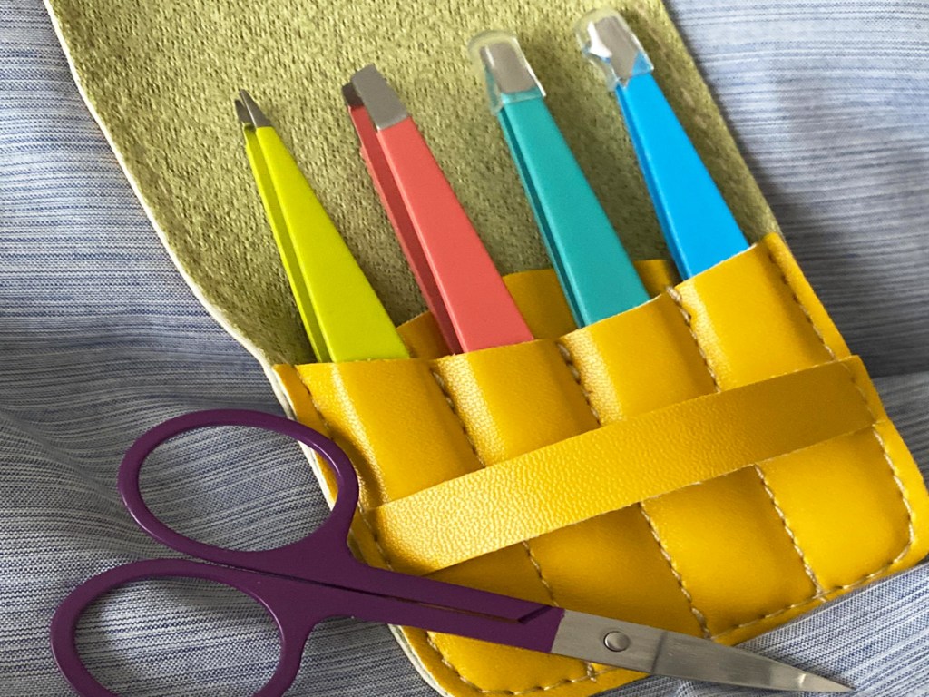 tweezers in yellow leather case with pair of purple scissors
