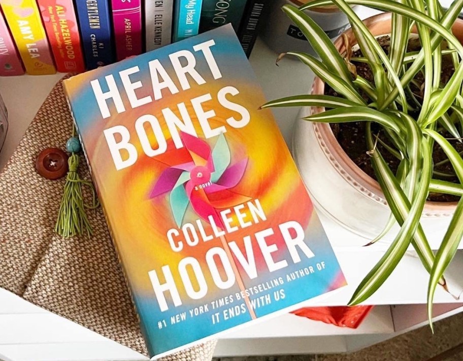 Heart Bones Colleen Hoover book on a shelf by other books and a plant