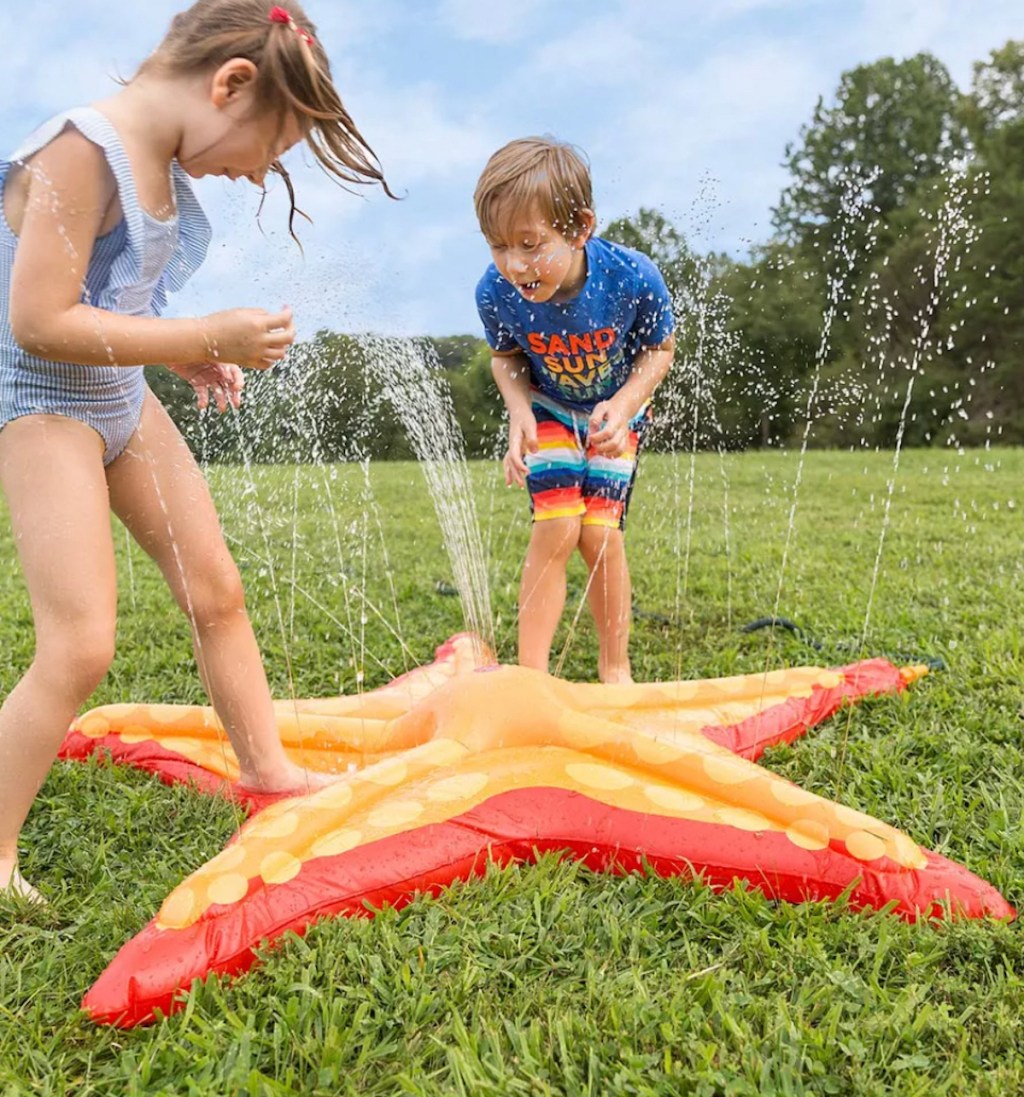 two kids playing in starfish shaped splash pad