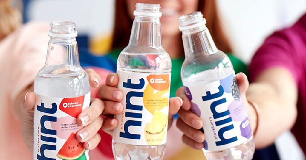 3 people holding 3 bottles of Hint water