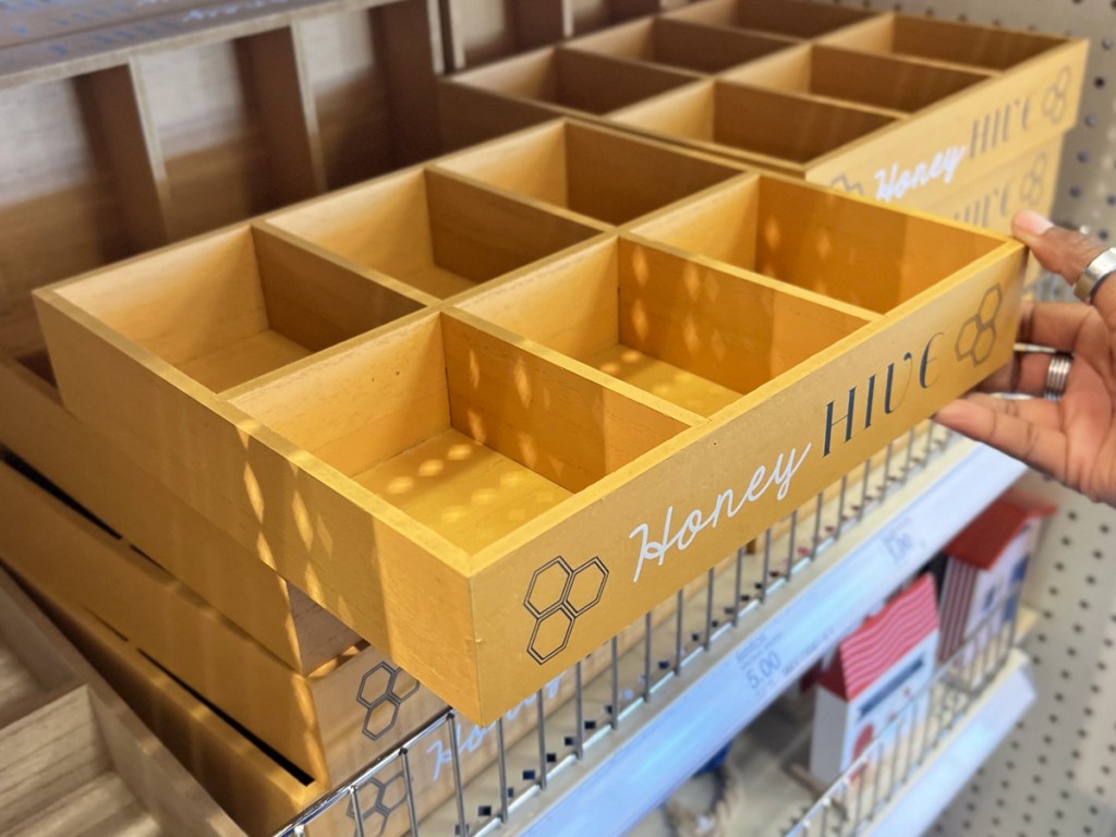 hand touching a wood tray with 6 dividers in it