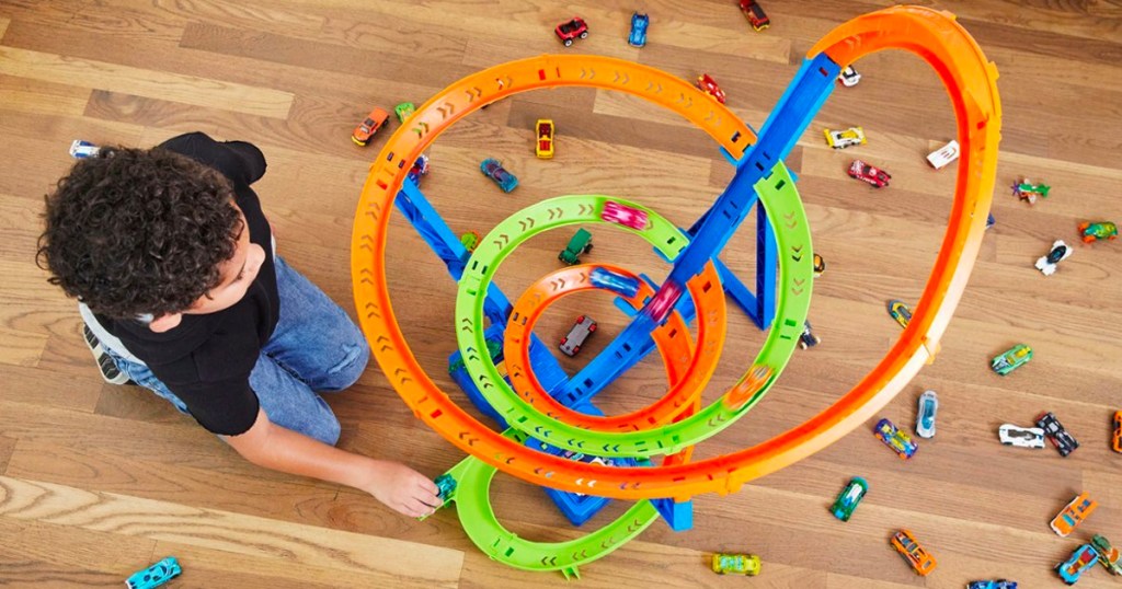 Overview of a kid playing with Hot Wheels Action Spiral Speed CrashTrack Set on a floor