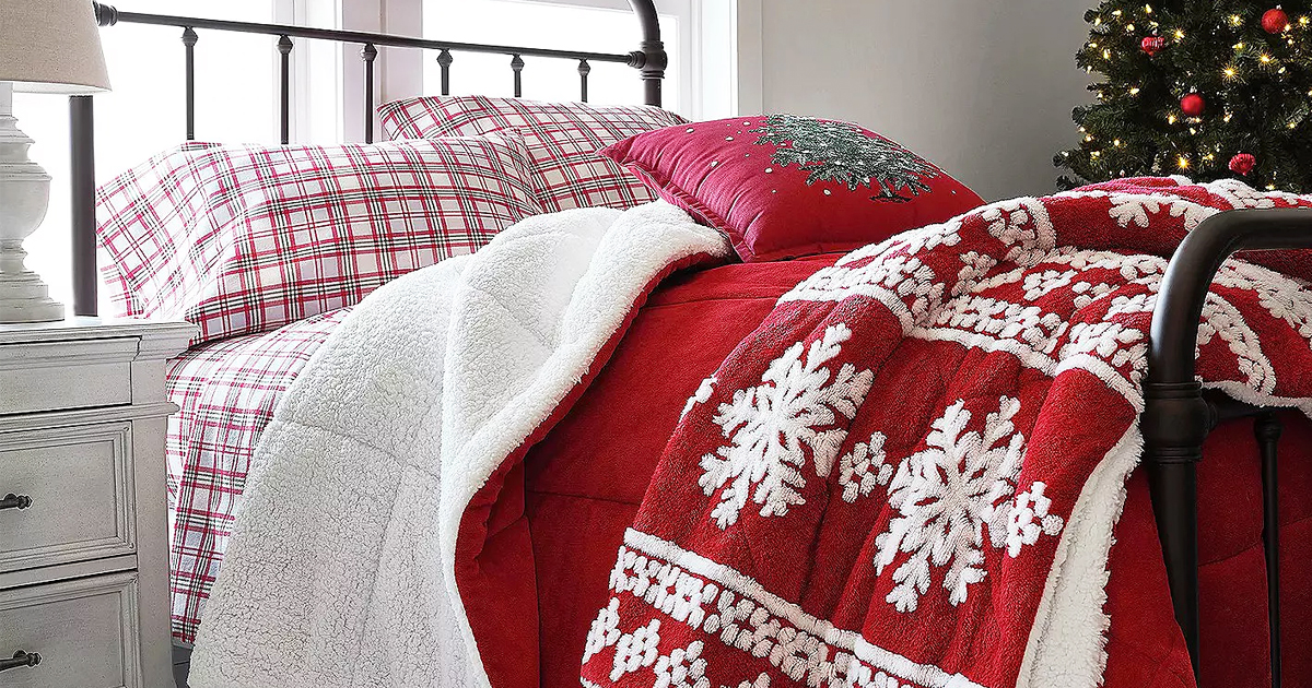 bed with plaid sheets, red comforter, and red and white snowflake print throw