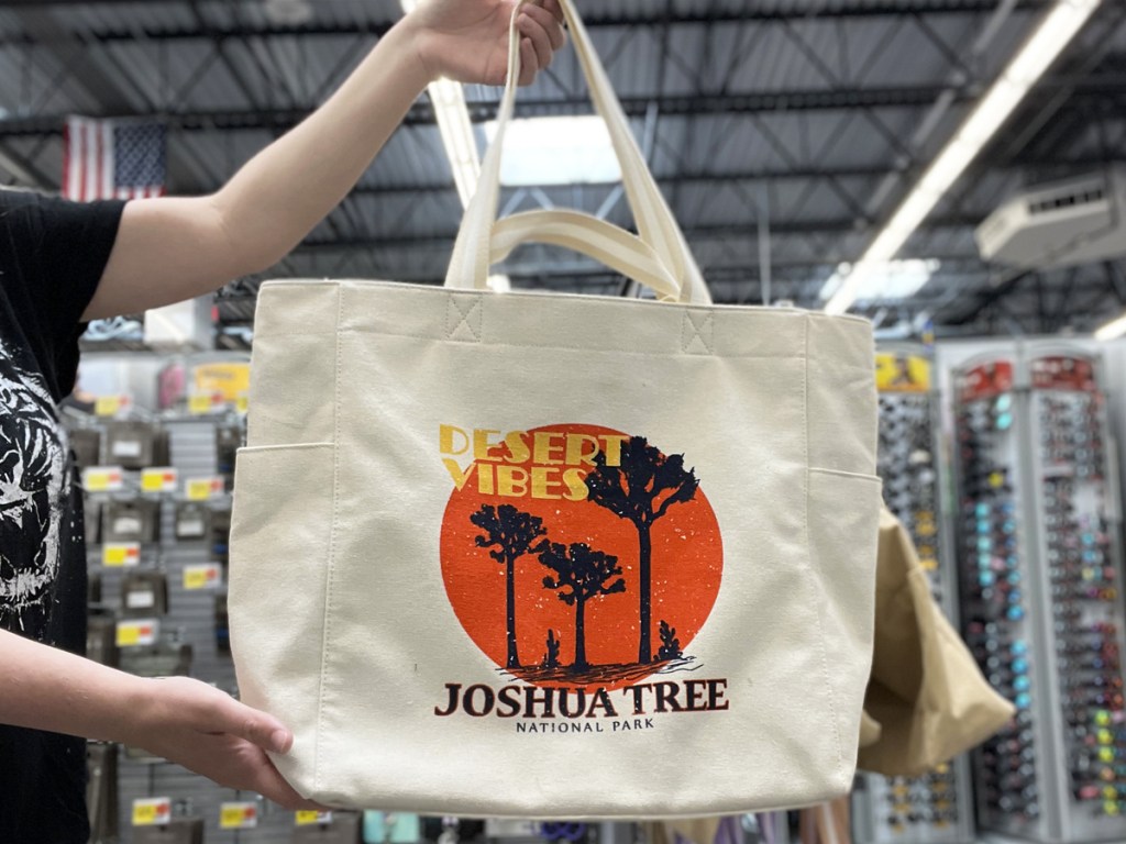 holding up a tote bag with joshua tree national park design on it