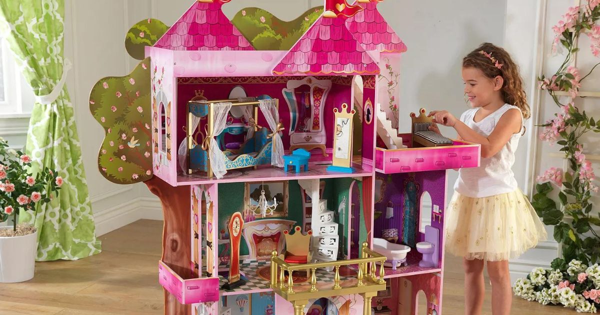 A child playing with a KidCraft Storybook Mansion Dollhouse