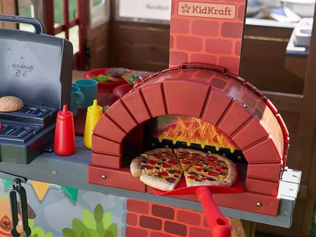 The woodfire oven on the KidKraft Grill & Chill Pizza Party Wooden Outdoor Playhouse