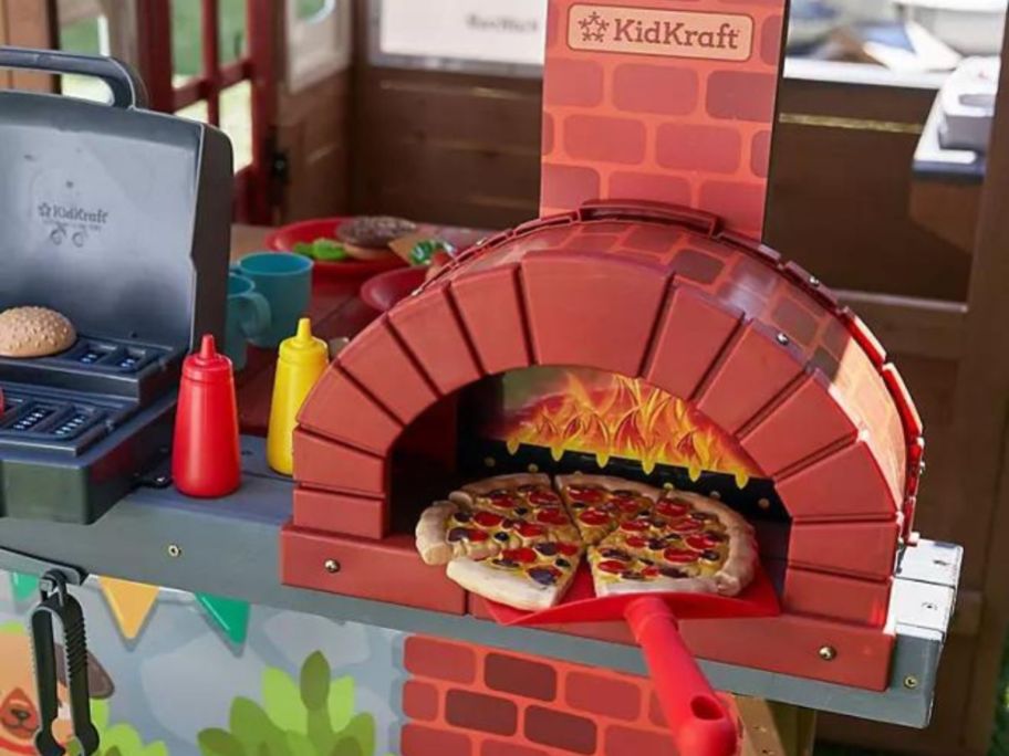The woodfire oven on the KidKraft Grill & Chill Pizza Party Wooden Outdoor Playhouse