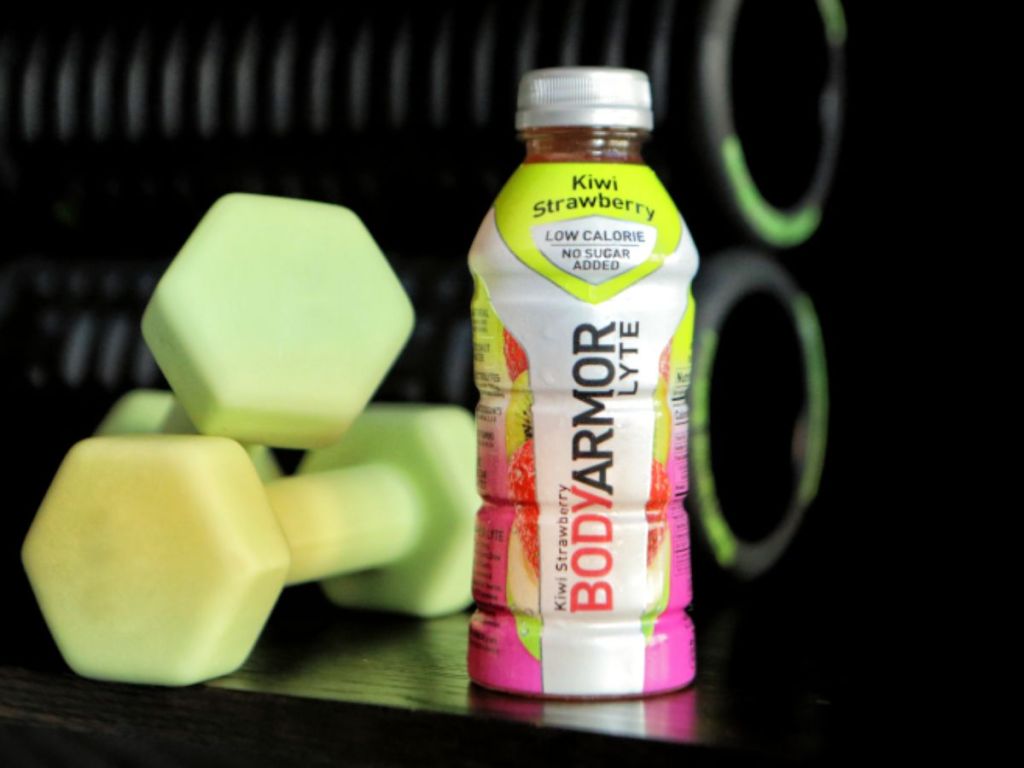 a bottle of Body Armor Kiwi Strawberry Lyte with dumbbells