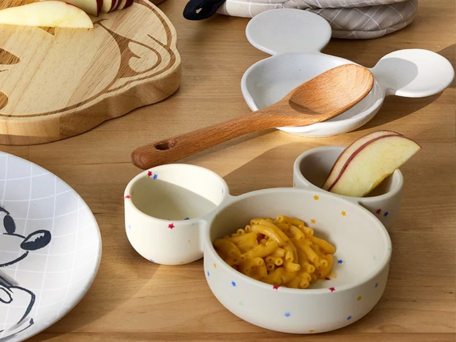 mickey mouse head shaped bowl and spoon rest on a table