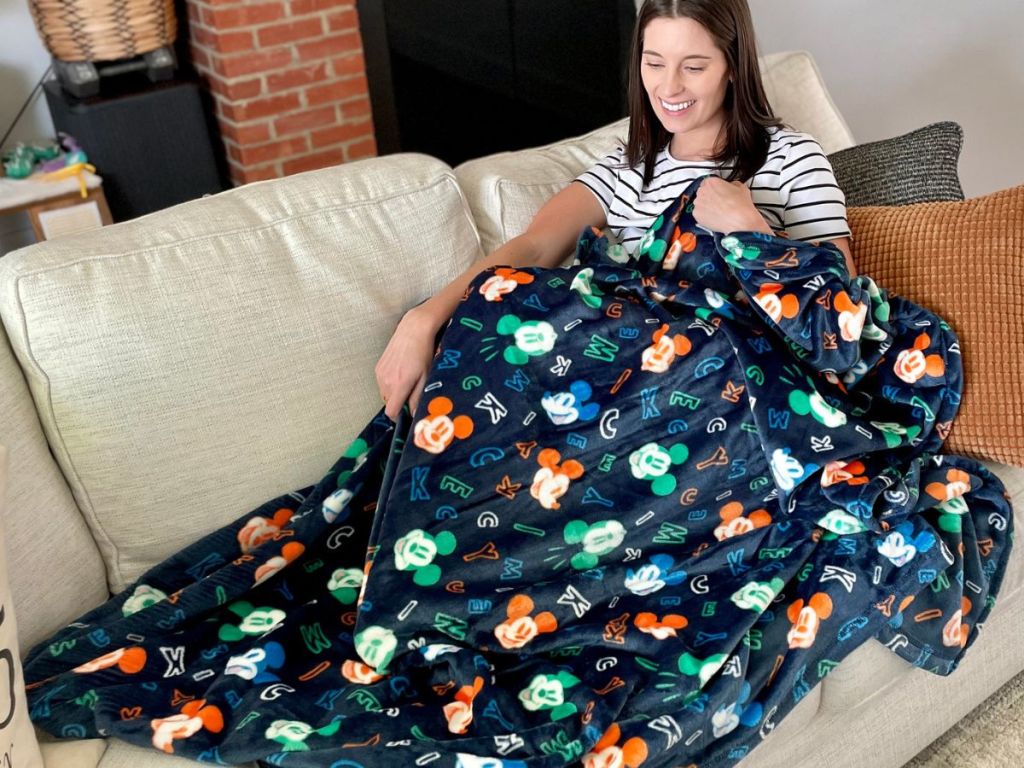 woman sitting on a couch with a blanket on her