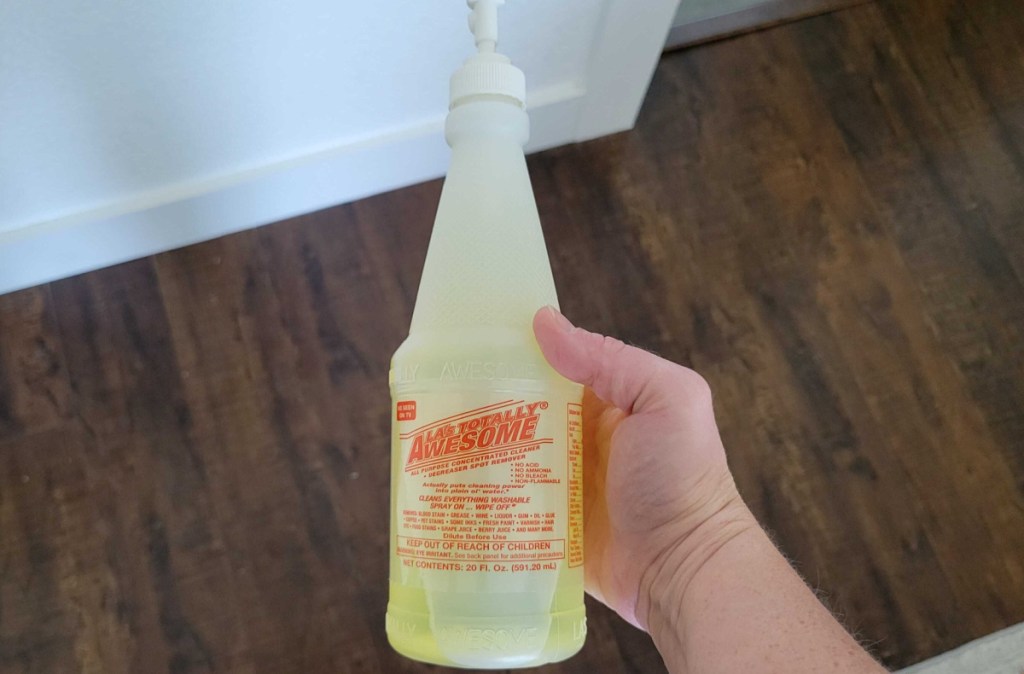 Hand holding a bottle of LA Totally Awesome All Purpose Cleaner