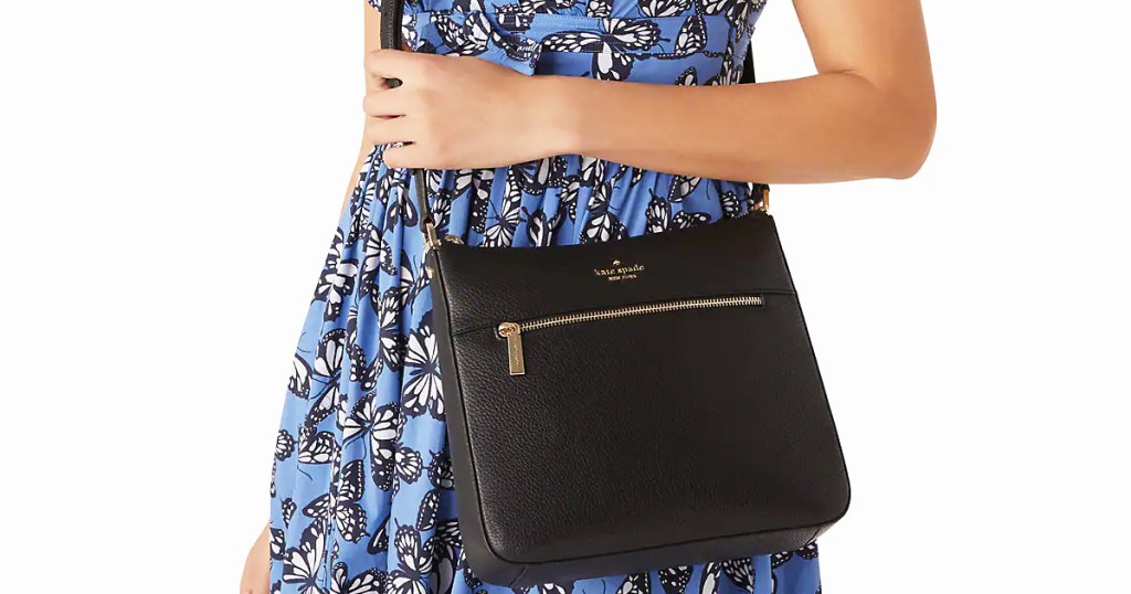 woman in blue butterfly print dress with black crossbody bag